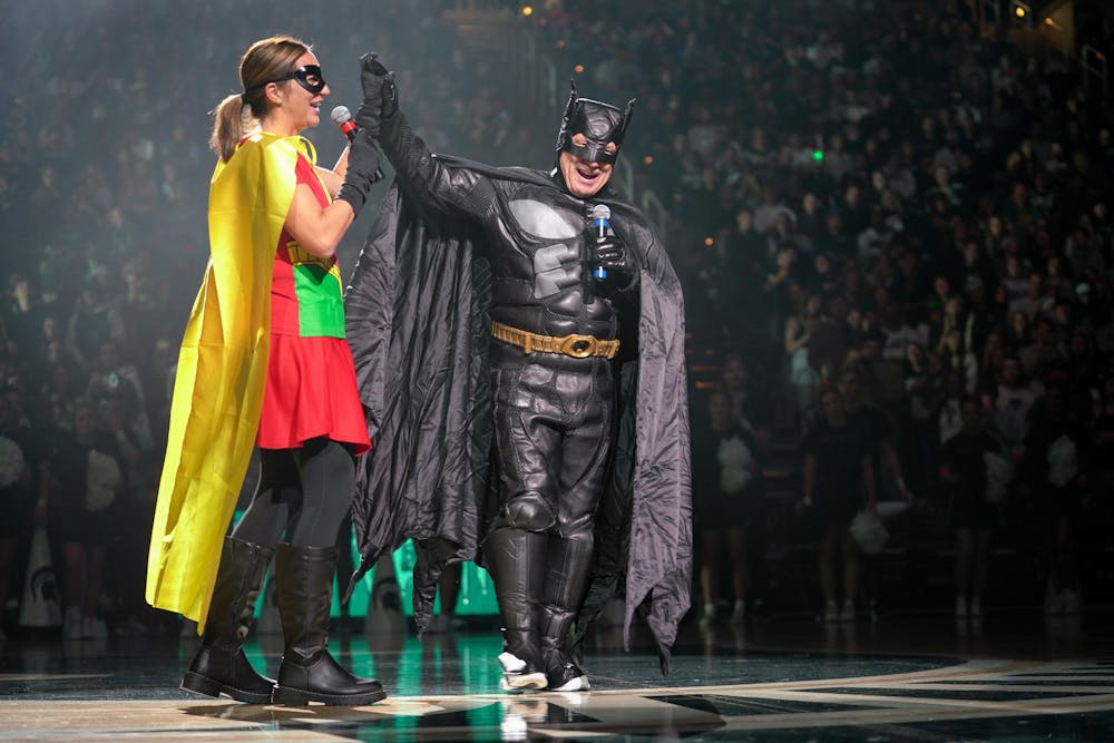 <p>Coach Robyn Fralick and coach Tom Izzo high-five at the Michigan State Madness event at the Breslin Center on Oct. 13, 2023. The two coaches were dressed in Batman and Robin costumes as part of the Friday the 13th theme.</p>