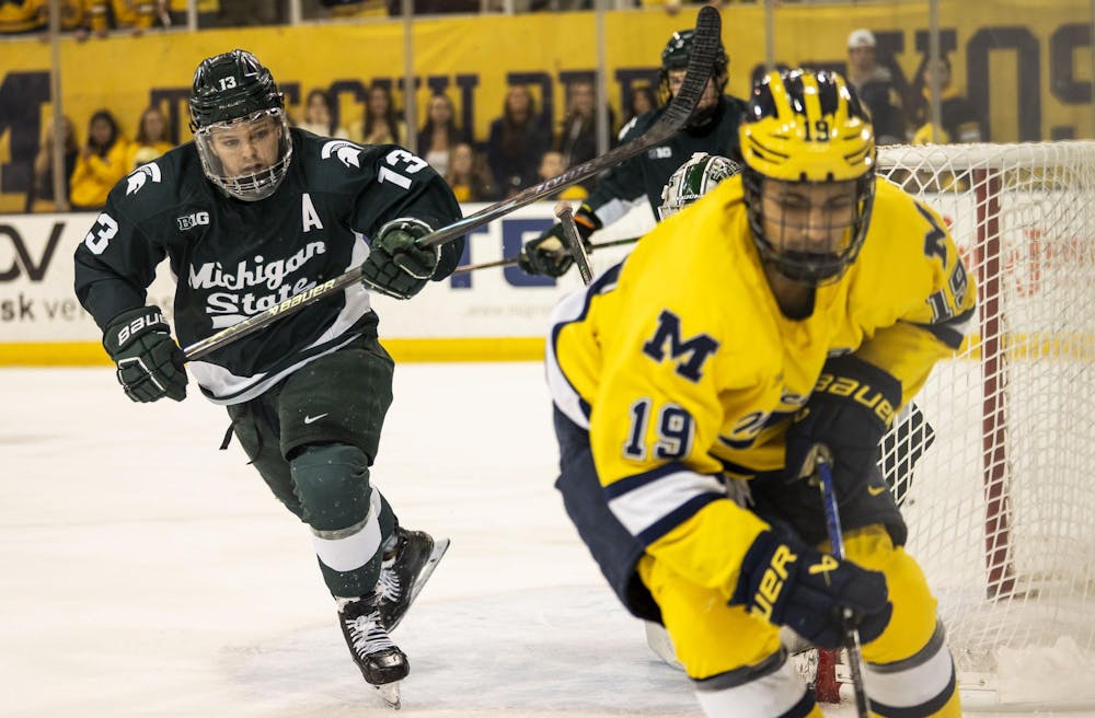 <p>Michigan State senior forward Tiernan Shoudy (13) skates towards University of Michigan sophomore forward Michael Hage (19) to get the puck at the Yost Ice Arena in Ann Arbor, Mich. on Dec. 6, 2025.</p>