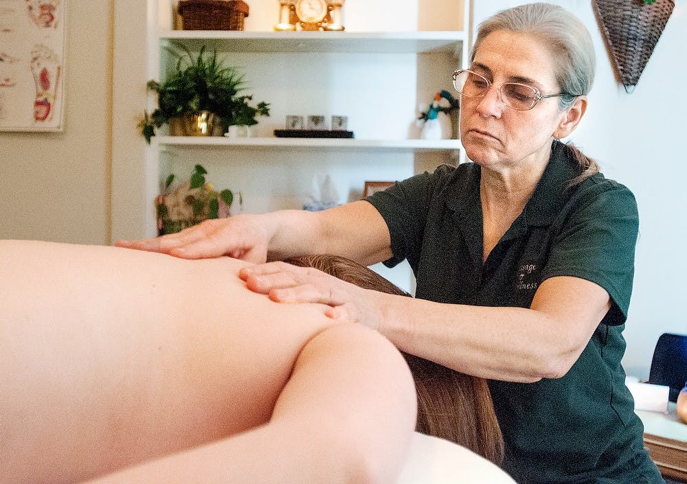 Massage therapist Susan Hossinger gives English freshman Taylor Neverman a massage Feb. 22, 2013, at Massage and Wellness, 201 E. Grand River. Neverman came to get a massage to help her with recent headaches. Julia Nagy/The State News