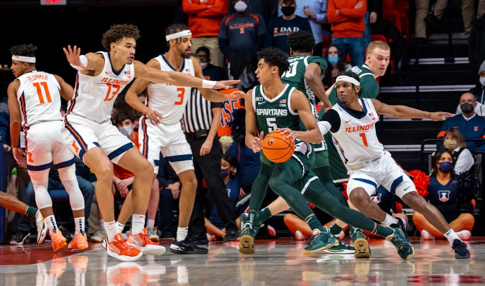 <p>Freshman guard Max Christie (5) dodges the Illinois defense in the first half. The Spartans lost to the Fighting Illini in the final seconds, 56-55, at State Farm Center on Jan. 25, 2022. </p>