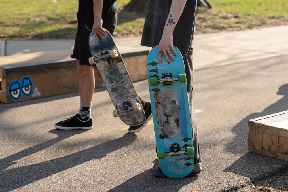 Members of MSU Skate Club hold their skateboards, showcasing the unique designs of each board, during skate club outside of Shaw Hall on Michigan State University’s campus in East Lansing, Mich., on March 20, 2026.