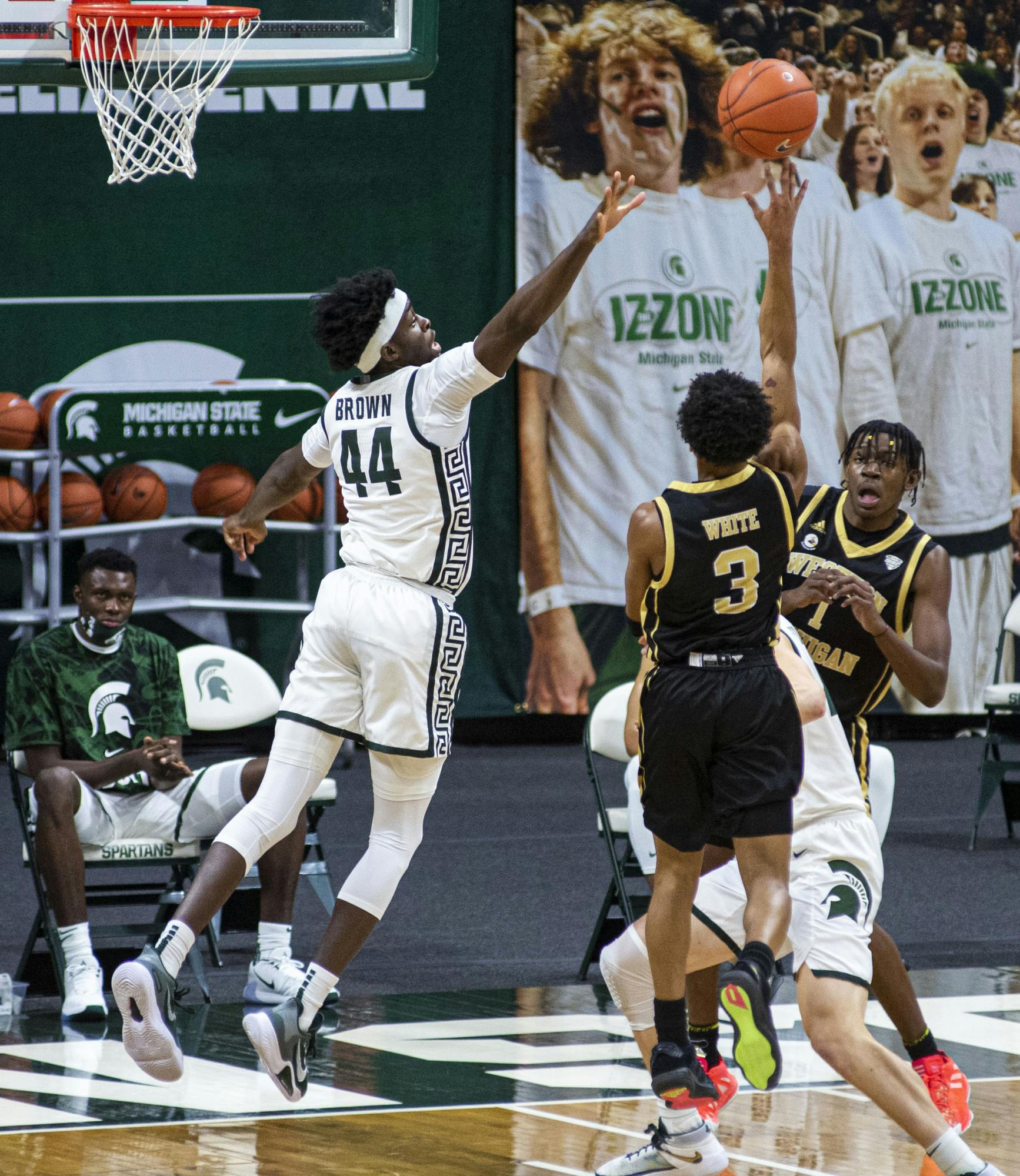 <p>Junior forward Gabe Brown (44) jumps to block a shot from Western Michigan&#x27;s B. Artis White (3) in the first half of the game. The Spartans came back in the second half to end the game against the Broncos, 79-61, on Dec. 6, 2020.</p>