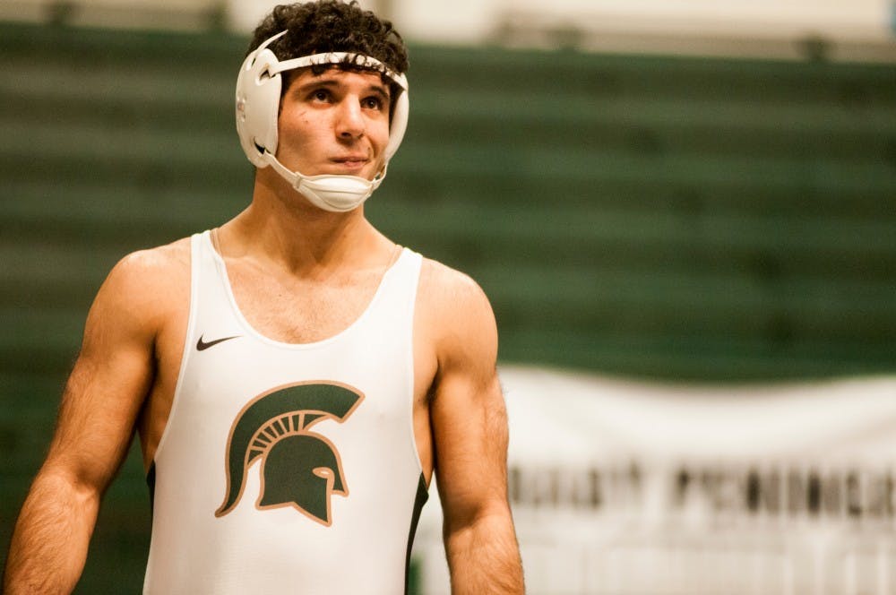 Freshman 197 pounder Jacob Cooper thinks about his next move on Jan. 15, 2015 at Jenison Field House.  For the first time in school history, the wrestling and gymnastics teams held a joint meet. 