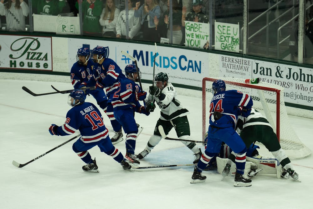 <p>Sophomore center Jesse Tucker (16) fights for control of the puck at Munn Ice Arena on Oct. 1, 2022. The Spartans lost to the USNTDP 4-3.</p>