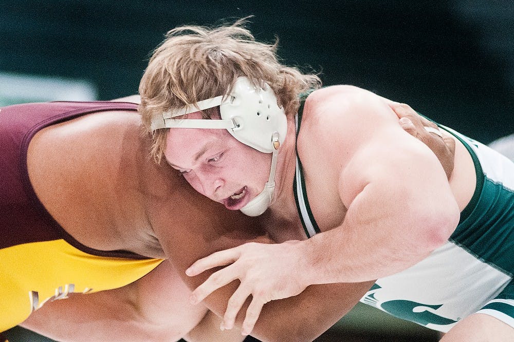 	<p>Junior heavyweight Michael McClure wrestles Central Michigan&#8217;s Jarod Trice on Feb. 22, 2013, at Jenison Field House. After two overtimes, McClure defeated Trice by nine seconds of riding time. Adam Toolin/The State News</p>