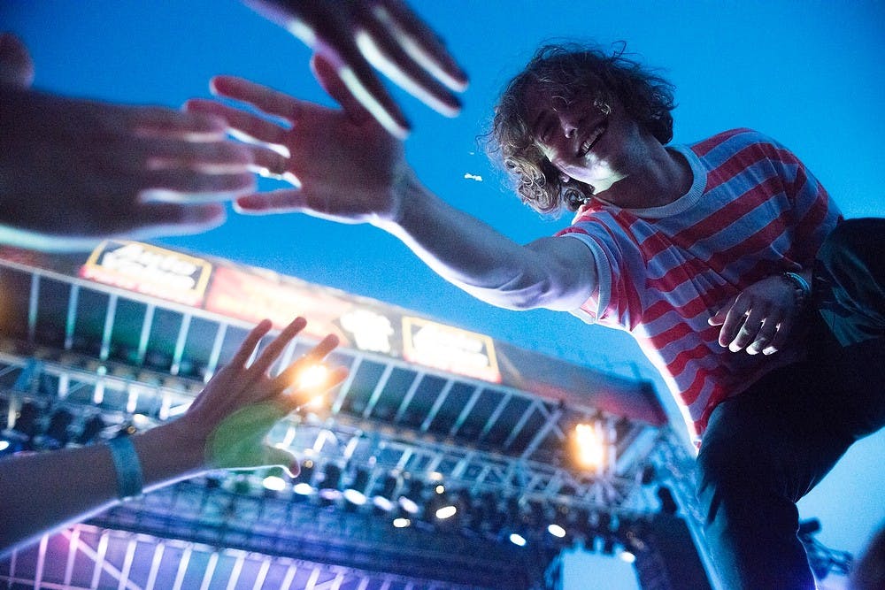 	<p><span class="caps">MGMT</span> lead vocalist Andrew VanWyngarden claps hands with fans, July 12, 2013, at Adado Riverfront Park in Lansing during Common Ground Music Festival. Friday&#8217;s performers appealed toward fans of alternative music. Justin Wan/The State News</p>