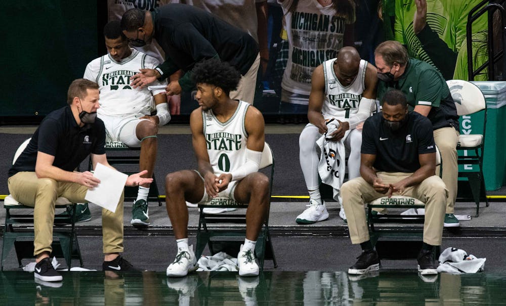 <p>Marcus Bingham Jr., Aaron Henry and Joshua Langford talk to their coaching counterparts during the second half of the game. The Hawkeyes crushed the Spartans, 88-58, on Feb. 13, 2021.</p>
