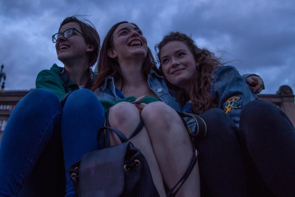 <p>Annie Barker (left), Haley Sinclair (middle) and Alyte Katilius (right) sit together in Prague on their photo communication in Europe study abroad.</p>