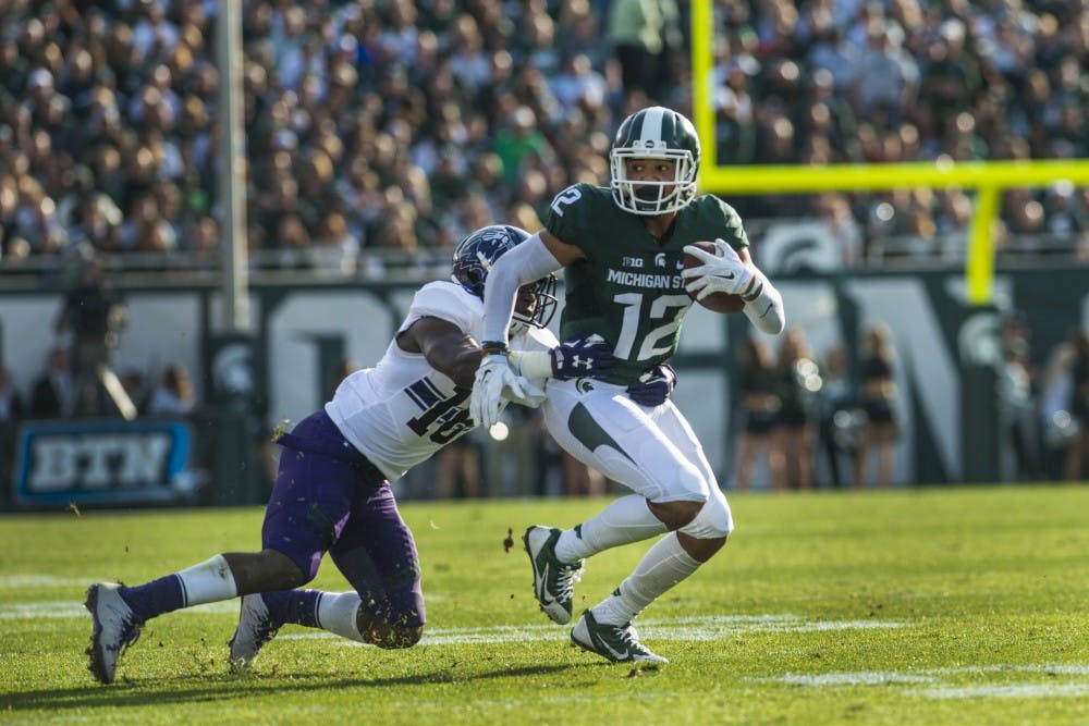 Senior forward R.J Shelton (12) catches the ball as Northwestern defensive back Dodwin Igwebuike (16) tackles during the second quarter of the game against Northwestern on Oct. 15, 2016 at Spartan Stadium.