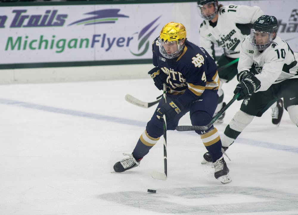 Notre Dame's Nick Leivermann (4) guards the puck from Michigan State's A.J. Hodges (10) on Feb. 26, 2021.