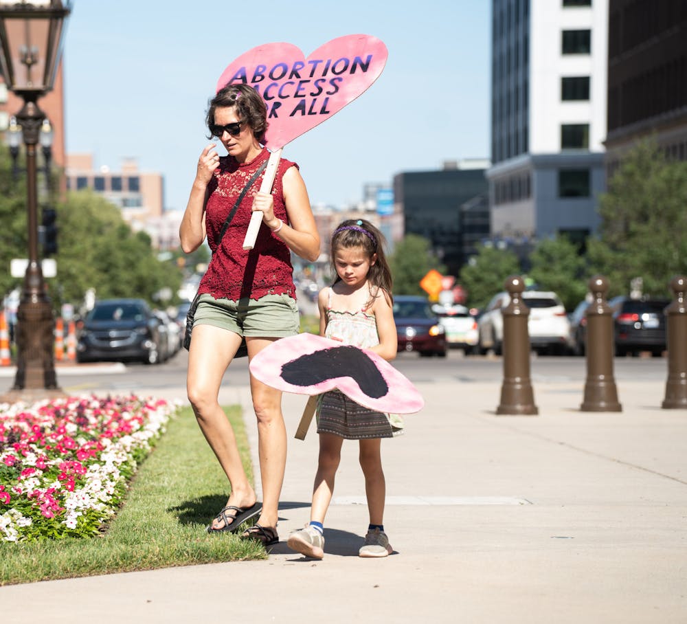 <p>A woman and a young girl walk on the Michigan State Capitol lawn as Abortion-rights protesters gathered on June 24, 2022. Abortion-rights protesters gathered after the Supreme Court overturned the constitutional right to an abortion, decided by Roe v. Wade in 1973, through their decision in the Dobbs vs. Jackson Women&#x27;s Health Organization case.</p>