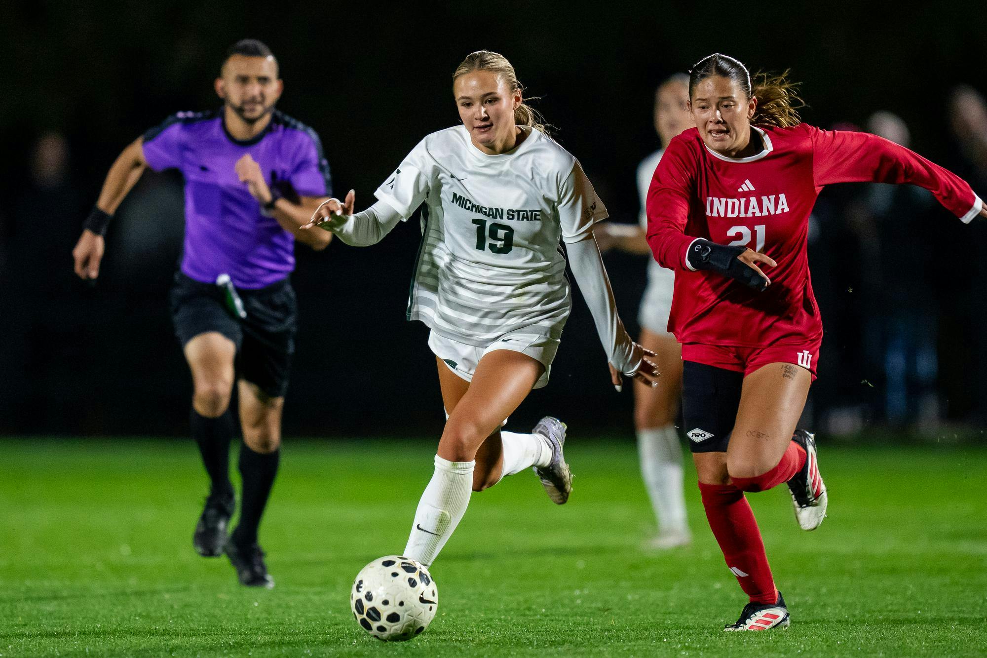 Senior and midfield Emerson Sargeant (19) moves the ball up field against Indiana’s freshman defender Grace Hamm at DeMartin Soccer Stadium in East Lansing, Michigan on Thursday, Oct. 16, 2025. 