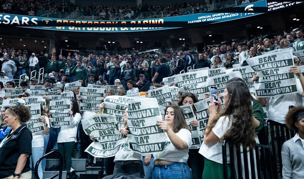 MSU fans hold up newspapers that say "Beat Villanova!" during a game against Villanova at the Breslin Center on Nov. 18, 2022. The Spartans defeated the Wildcats 73-71. 