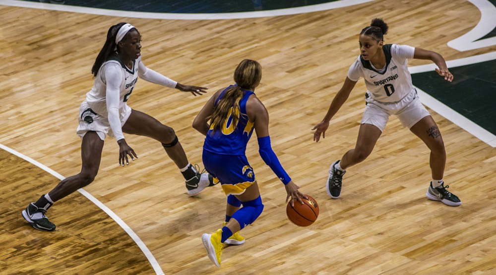 <p>Farquhar (2) and freshman guard Deedee Hagemann (0) watch Eagles graduate student guard Terri Smith (30) as she nears the basket in the Spartan’s match against Morehead State at the Breslin Center on Tuesday, Nov. 9, 2021. </p>