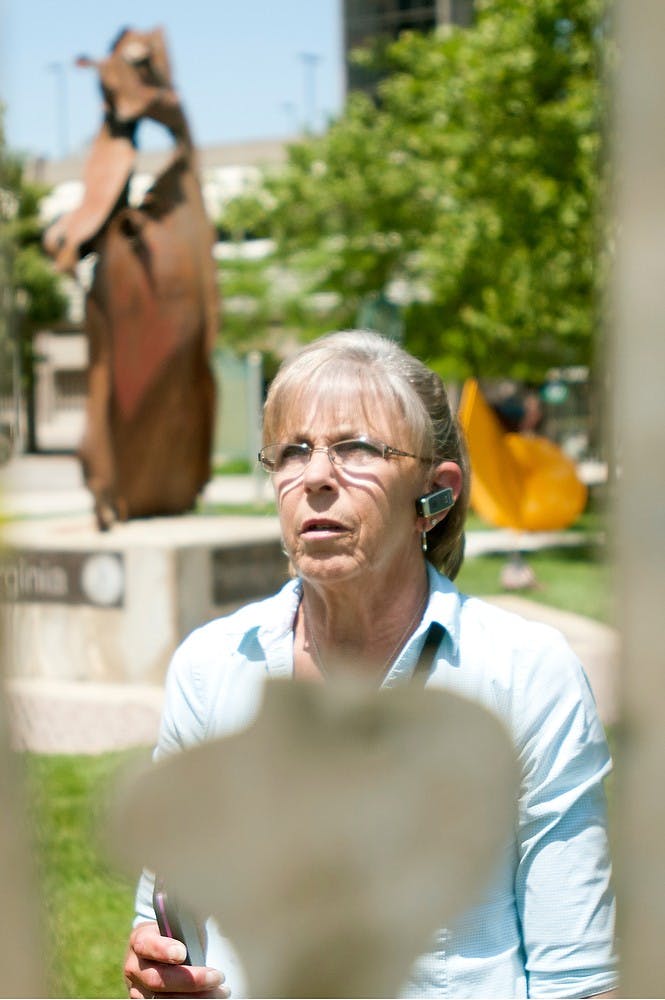 	<p>Lansing resident Elyse Gottschalo looks at a piece of art at Wentworth Park on June 4, 2013. Sculptures in the park continues until August 30, 2013. Weston Brooks/The State News</p>