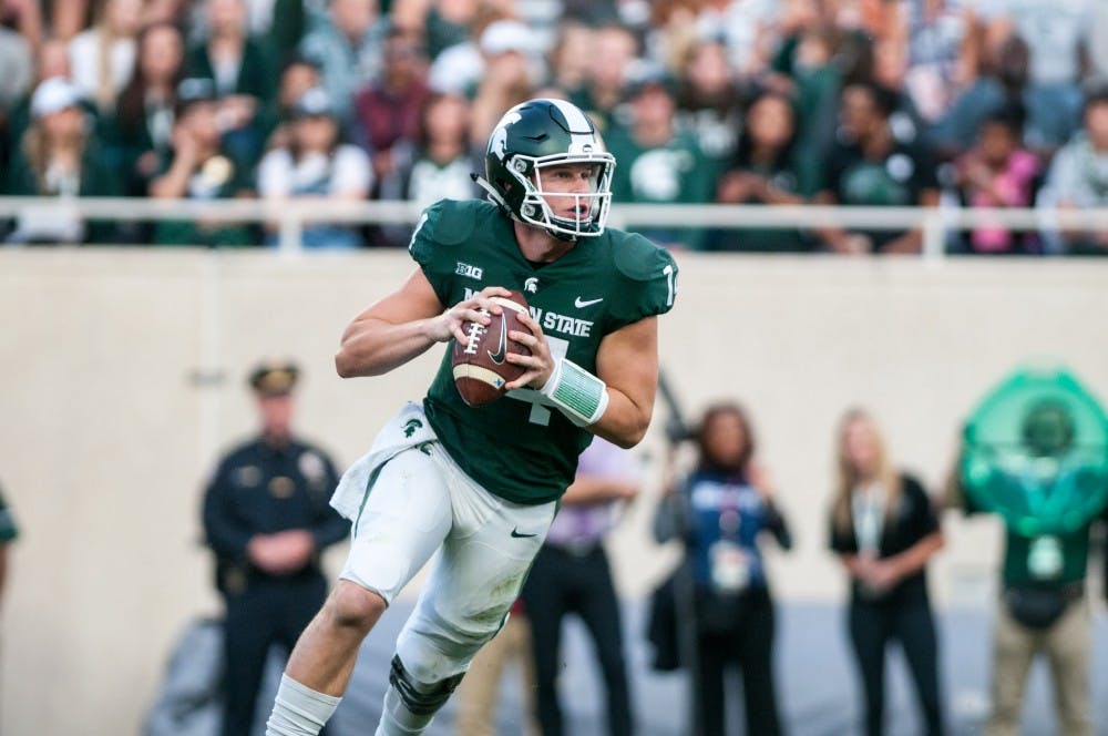 Sophomore quarterback Brian Lewerke (14) rolls out during the game against Indiana on Oct. 21, 2017, at Spartan Stadium. The Spartans defeated the Hoosiers, 17-9.