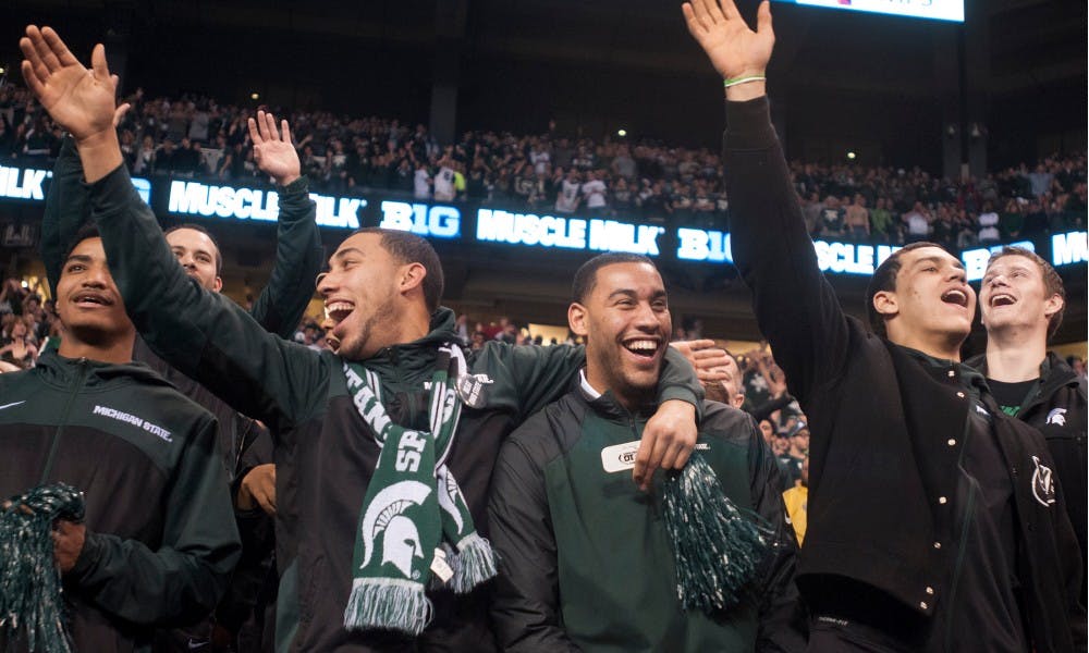 Sophomore guard Denzel Valentine and brother Drew celebrate with the men's basketball team during the Big Ten Championship game against Ohio State on Dec. 7, 2013, at Lucas Oil Stadium in Indianapolis, Ind. The Spartans defeated the Buckeyes, 34-24. Danyelle Morrow/The State News
