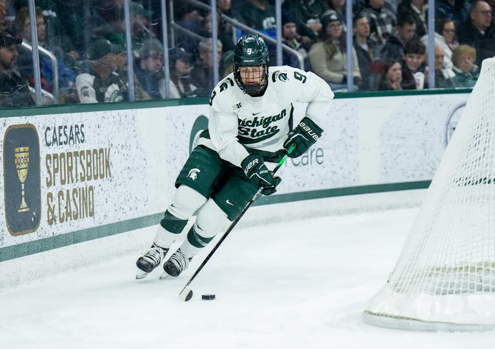 <p>Freshman defender Matt Basgall (9) dribbles the puck during a game against Notre Dame at Munn Ice Arena on Feb. 3, 2023. The Spartans defeated the Fighting Irish 3-0.</p>