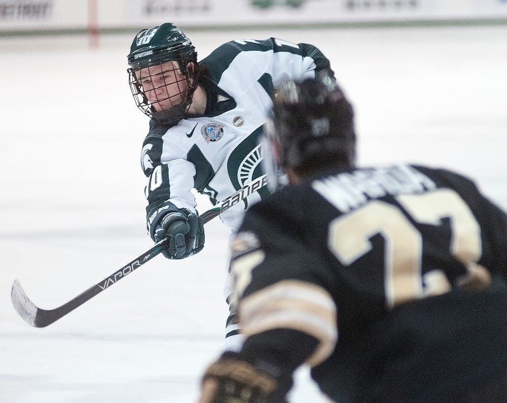 Sophomore right wing Tanner Sorenson takes a slap shot Friday, March 1, 2013, at Munn Ice Arena. Western Michigan defeated the Spartans, 5-2, during the first game of the weekend series. Adam Toolin/The State News