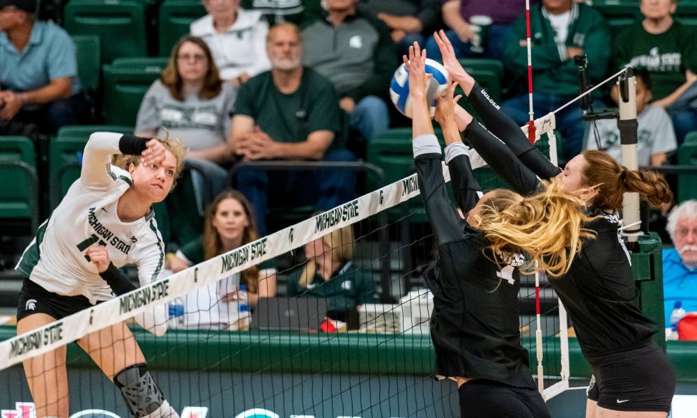 <p>Junior outside hitter Alyssa Chronowski (11) has her spike blocked against Oakland. The Spartans defeated the Golden Grizzlies, 3-0, at Jenison Field House on Sept. 12, 2019.</p>