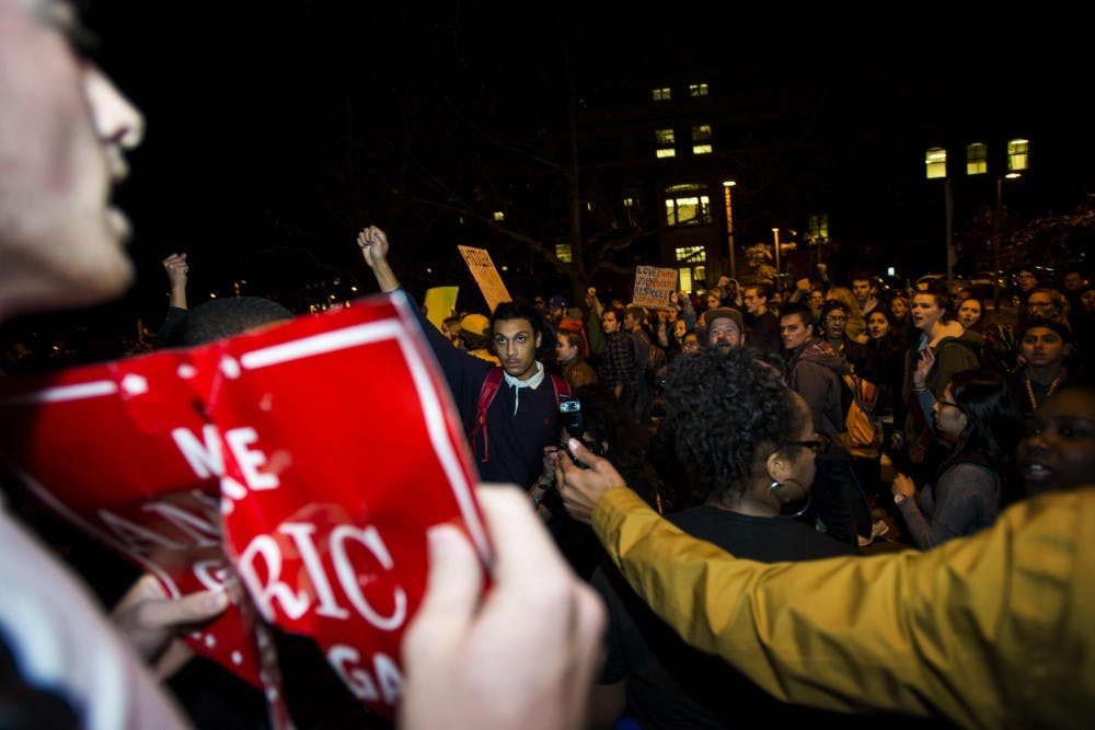 Protesters yell at a student holding a sign that states "Make America Great Again" on Nov. 10, 2016 along West Circle Drive. Thousands of students gathered together to unite and support one another in a rally against hate, bigotry, racism and sexism.
