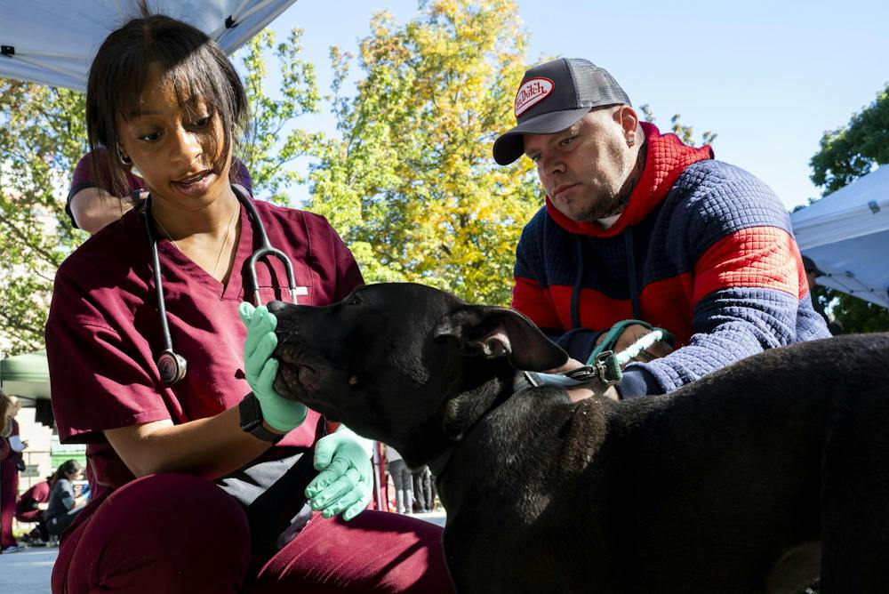 <p>A Michigan State University second-year veterinary medicine student examines Melly, a 9-month-old pit bull owned by Patrick Stephens, 43, of Lansing, during a free veterinary clinic hosted by the Michigan Community Street Clinic at Reutter Park in Lansing, Mich., on Sunday, Sept. 27, 2026.</p>