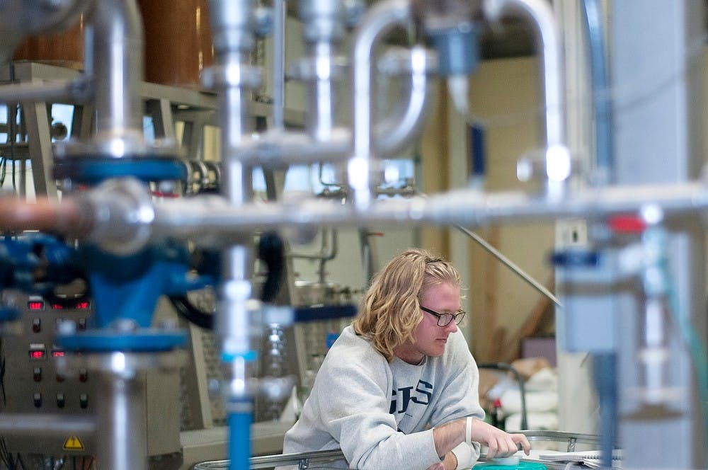 	<p>Biosystems engineering senior and secretary of the <span class="caps">MSU</span> distilling club Jamie Burns waits during the distilling process of brandy Feb. 20, 2014, at Red Cedar Spirits. <span class="caps">MSU</span> students formed this club within the last week following the creation of the <span class="caps">MSU</span> Artisan Distilling Program and the distillery/tasting room. Betsy Agosta/The State News</p>