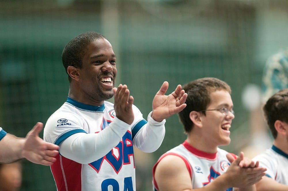 	<p>Pittsburgh, Penn. resident Blaze Foster applauds his teammates after a point is scored, during a volleyball set of the 2013 World Dwarf Games, Aug. 8, 2013, at Jenison Field House. Foster, along with his teammates, went on to win a gold medal. Danyelle Morrow/The State News</p>