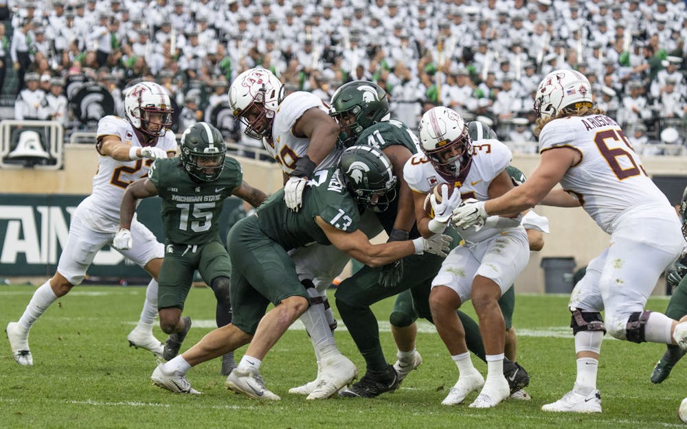 <p>Redshirt senior linebacker Ben VanSumeren, 13, attempts to tackle Trey Potts, 3, during Michigan State’s match against Minnesota on Saturday, Sept. 24, 2022. The Gophers ultimately beat the Spartans, 34-7.</p>