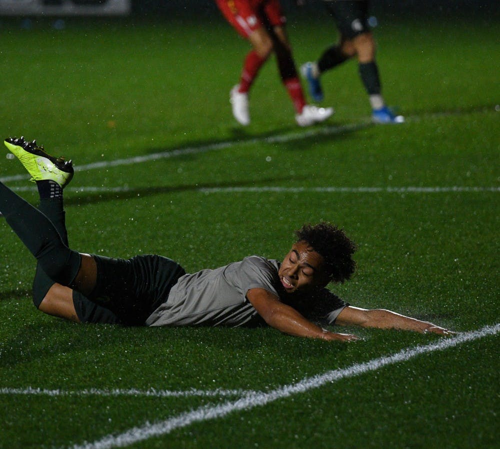 <p>Sophomore defender Olu Ogunwale (14) slides during the game against Maryland at DeMartin Stadium on October 11, 2019. The Spartans tied the Terrapins 1-1.</p>