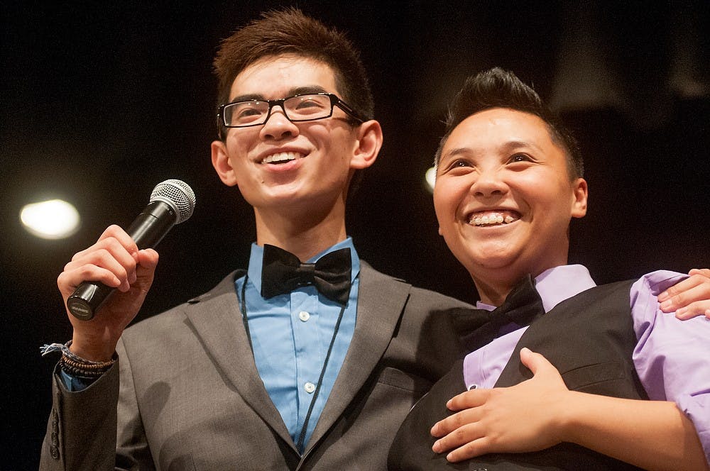 	<p>Marketing and advertising sophomore Adam Lam (left) wraps his arm around psychology senior Jen Nguyen (right) before announcing the winner of Kollaboration&#8217;s talent show on Sept. 21, 2013, at Chippewa Middle School, Okemos, Mich. Kollaboration is a community of Asian and Pacific Islander students that focuses on entertainment and performing arts. Georgina De Moya/The State News</p>