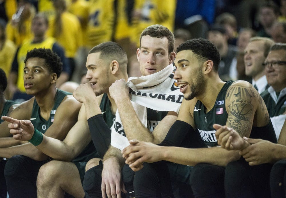 From left to right, junior guard Eron Harris, junior forward Gavin Schilling, senior forward Matt Costello, and senior guard Denzel Valentine converse on the bench during the game against Michigan on Feb. 6, 2016 at Crisler Center in Ann Arbor, Mich.  The Spartans defeated the Wolverines 89-73.