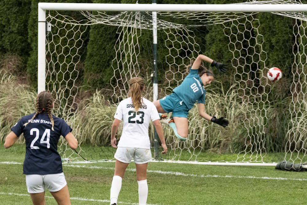 <p>Redshirt junior goalkeeper Lauren Kozal (00) jumps to catch a ball at the net during the game against Penn State on Oct. 24, 2021. The Spartans were defeated by the Nittany Lions 1-2.</p>