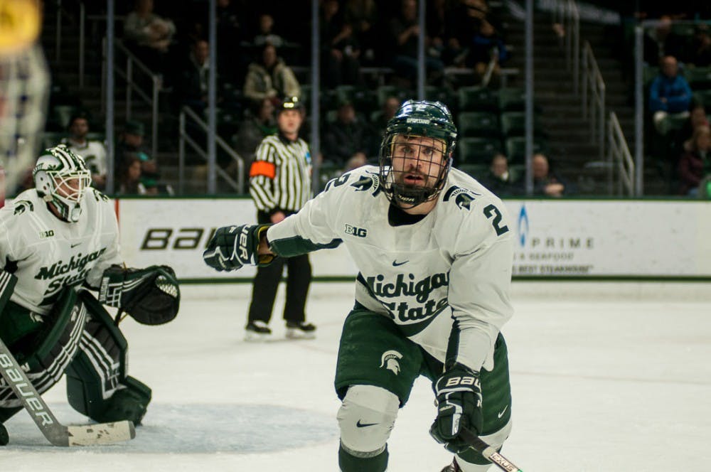 <p>Senior defense Zach Osburn (2) looks at a Notre Dame player during the game against Notre Dame on Nov. 16, 2018 at Munn Ice Arena. The Fighting Irish were ahead, 1-0 after the first period. &nbsp;</p>