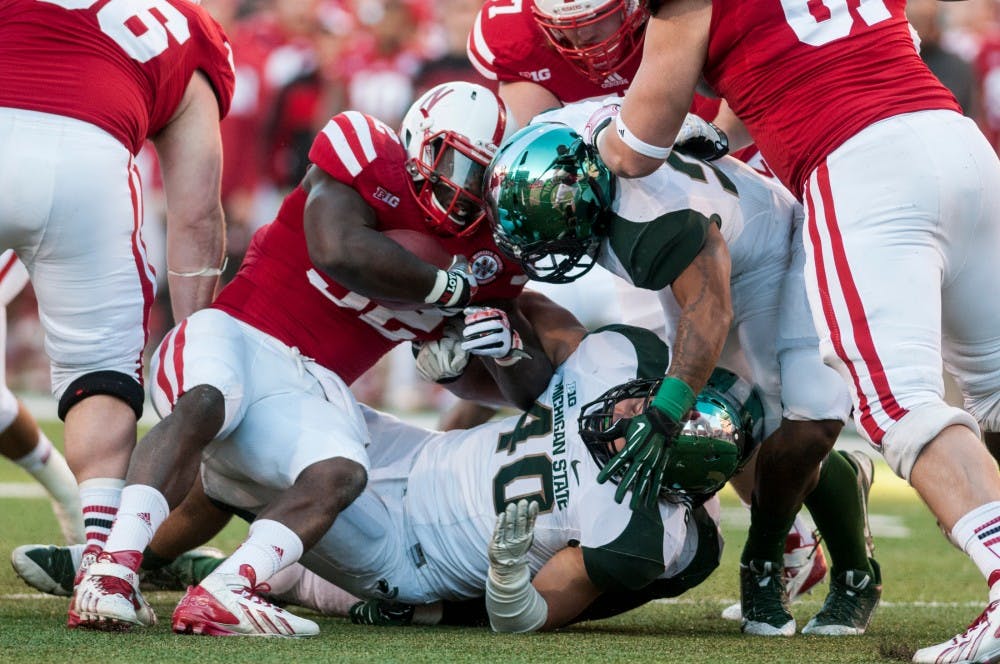 	<p>Senior linebackers Max Bullough and Denicos Allen take down Nebraska running back Imani Cross during the game against Nebraska on Nov. 16, 2013, at Memorial Stadium in Lincoln, Neb. The Spartans defeated the Cornhuskers, 41-28. Khoa Nguyen/The State News</p>