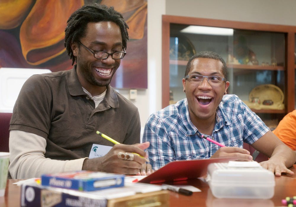 Microbiology senior Gavin Rienne, left, laughs with psychology junior Jimmy Johnson while playing Scattergories at QPOCALYPSE on Monday, Sept. 24, 2012, held in the Multicultural Center in the Union. QPOCALYPSE invited sexual and racial minorities to enjoy food, games, and music. Griffin Zotter/The State News