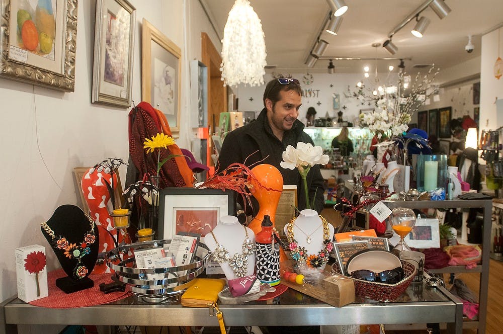 <p>Ann Arbor, Mich., resident Andrea Pertosa browses various art items on Nov. 1, 2014, at Katalyst Art Gallery and Gift Boutique, 1214 Turner St. in Lansing. More than 200 artists are represented in the gallery. Jessalyn Tamez/The State News. </p>