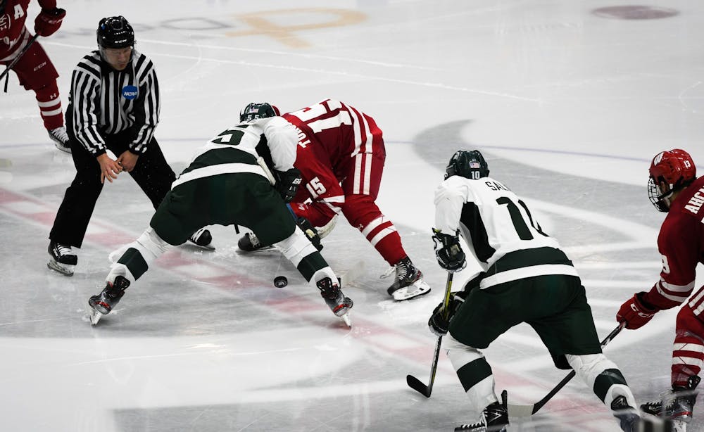 Players in a face-off during the game against Wisconsin at the Munn Ice Arena on December 6, 2019.  The Spartans defeated the Badgers 3-0.