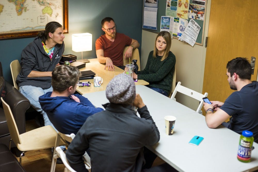 Graduate student Emily Young, center, holds onto the talking skeleton as she talks about her week during the MSU Traveler's Club meeting on March 31, 2017 at Olin Health Center. The MSU Traveler's Club is a club that provides a social space and support for people who are in recovery from addiction. 