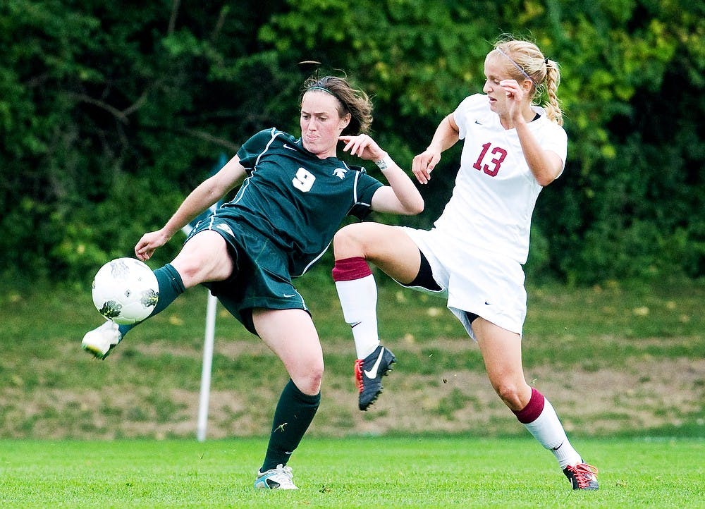 	<p>Junior midfielder Jordan Mueller kicks the ball away from Minnesota forward Steph Brandt on Sept. 25, 2011 at DeMartin Stadium at Old College Field. The Spartans defeated the Golden Gophers 3-0. State News File Photo</p>