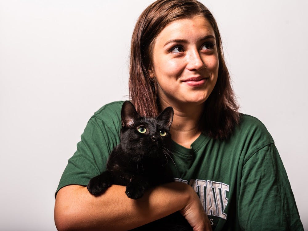 <p>MSU student Arlene Bradford holds her cat, Willow, while posing for a photo July 10, 2019. Playing with animals can be a great way to relieve the stress and anxiety that builds up throughout a semester.</p>