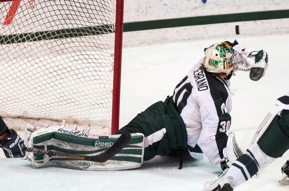 Freshman goaltender Jake Hildebrand reaches out to make a save March 2, 2013, at Munn Ice Arena. MSU beat Western Michigan 1-0 in Hildebrand's first career shutout. Danyelle Morrow/The State News