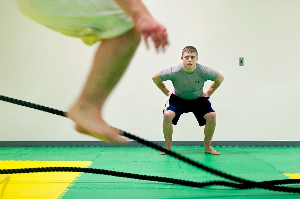 	<p>Mechanical engineering sophomore Casey Nottingham, right, practices mixed martial arts as he watches gradate student Austin Gregory, front, leap forward Sunday, Feb. 17, 2013 in the basement of IM-Sports West. </p>