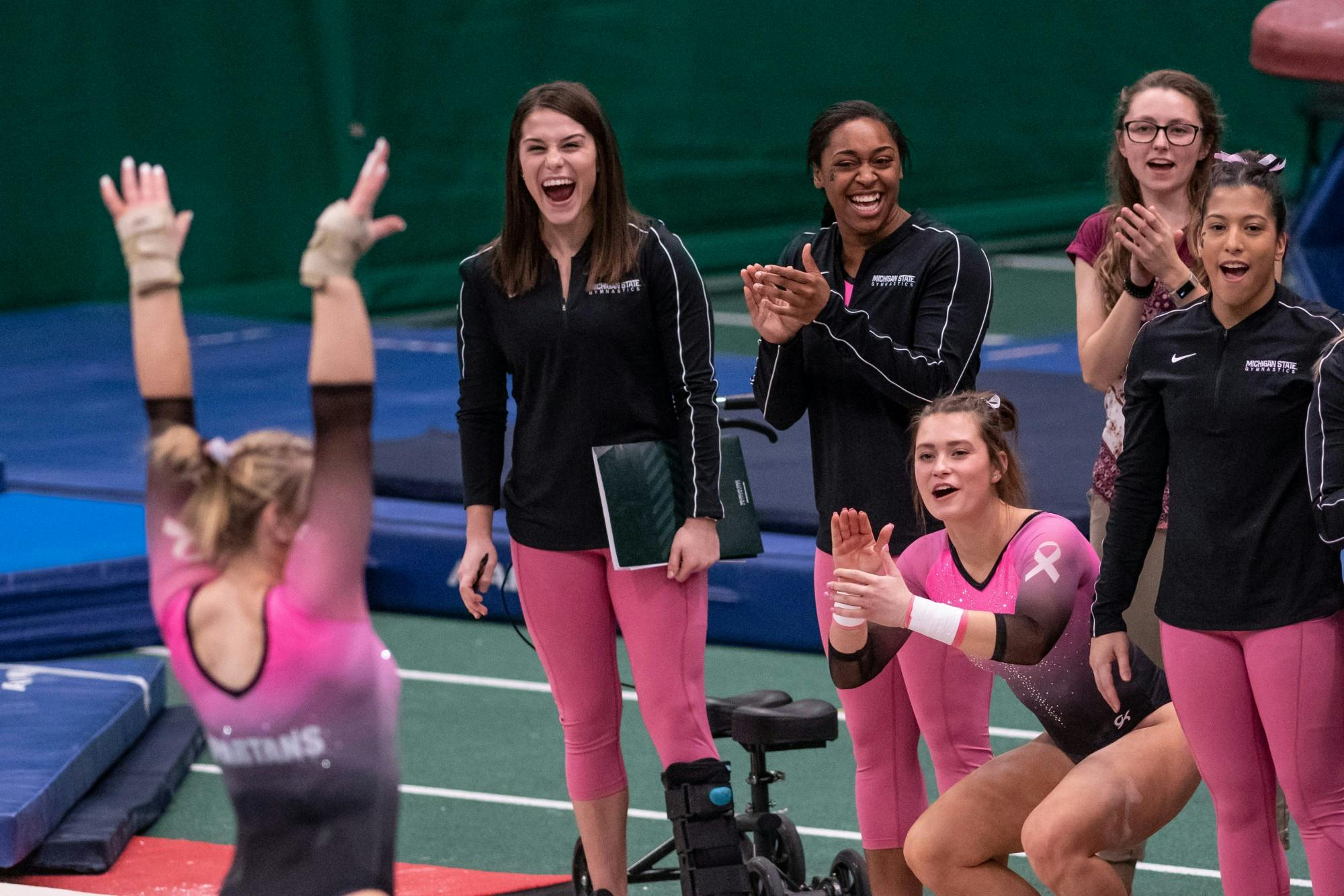 <p>The Spartans cheer for Chloe Bellmore during the meet against Minnesota Jan. 18, 2020 at Jenison Fieldhouse. The Spartans defeated the Buckeyes, 195.450-195.325.</p>