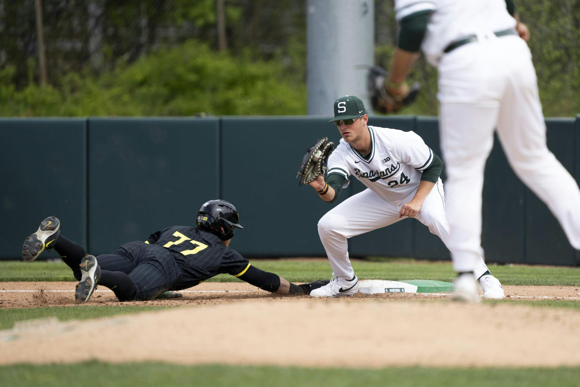 An Oregon player slides back into first base at McLane Stadium on May 3, 2025.