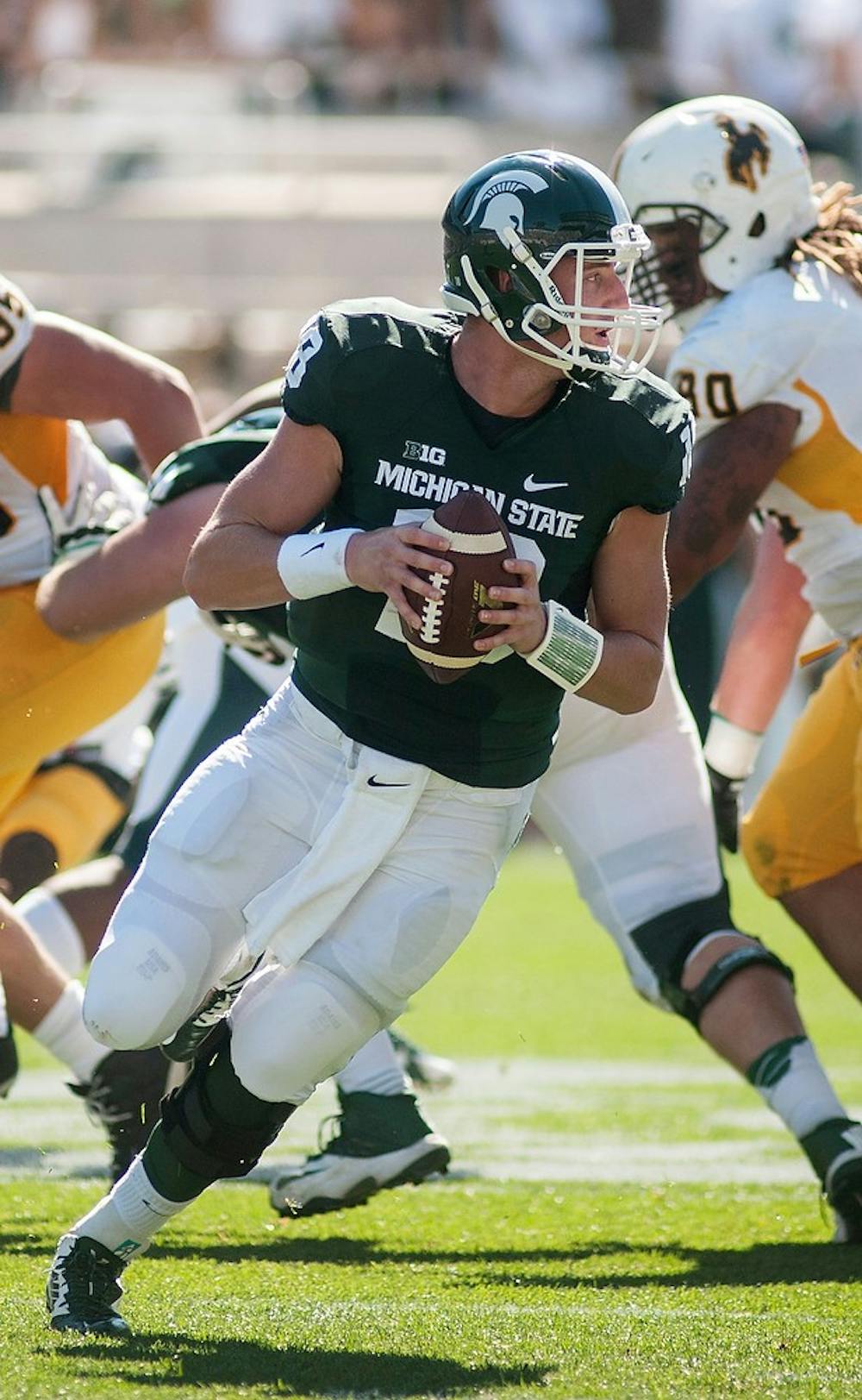 <p>Junior quarterback Connor Cook looks to pass during the game against Wyoming on Sept. 27, 2014, at Spartan Stadium. The Spartans defeated the Cowboys, 56-14. Raymond Williams/The State News</p>