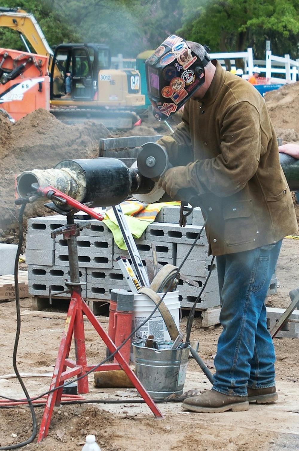 <p>Charlotte, Mich., resident Mike Cousino welds chilled water lines May 9, 2014, while doing construction near Landon Hall. Summer construction began May 5, 2014, and many of the projects are set to be completed by the beginning of the 2014 school year. Corey Damocles/The State News</p>