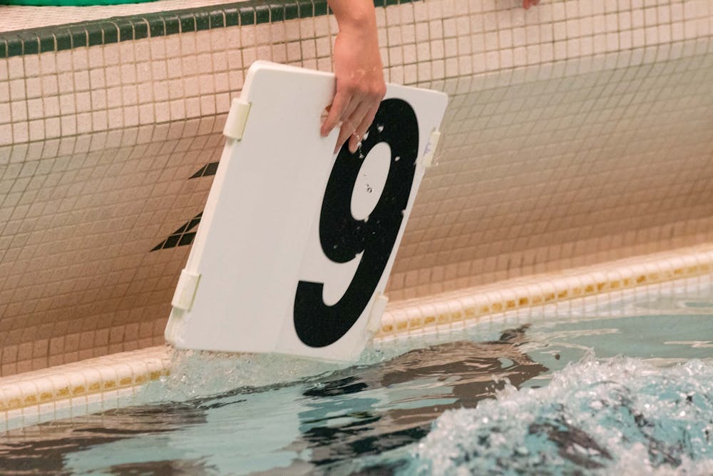 A Spartan swimmer pulls a sign out of the water during the meet against Cleveland State Jan. 24, 2020 at McCaffree Pool. The Spartans defeated the Vikings, 163.5-135.5.