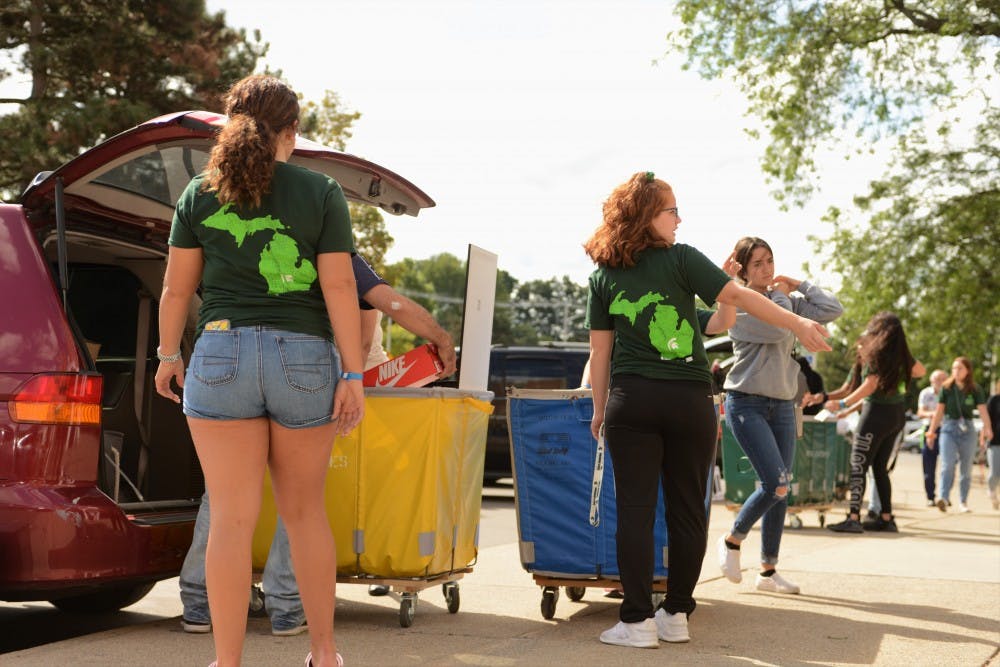 <p>Hall employees help direct new students during Fall move in day at South Hubbard Hall on Aug. 25, 2019.</p>