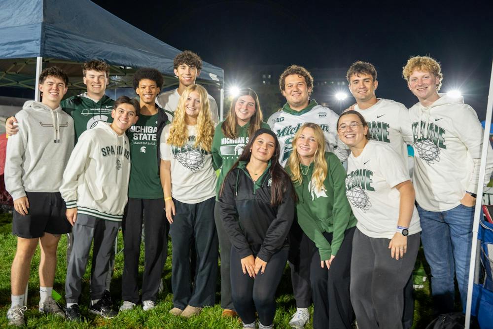 <p>A group of friends pose for the camera at the Izzone Campout on Munn Field in East Lansing, Mich., on Friday, Oct. 2, 2026.</p>